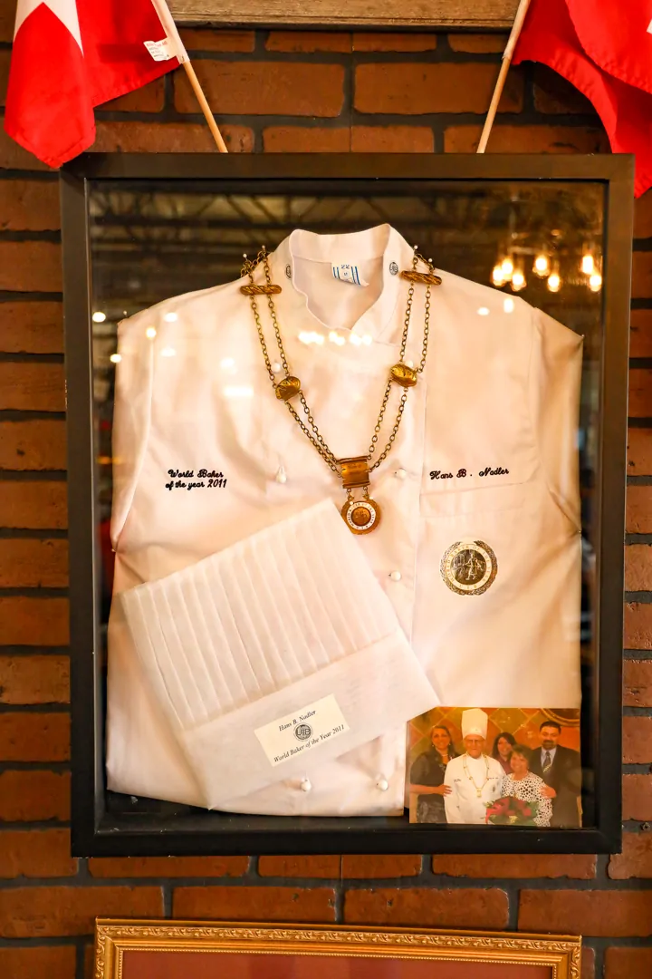 Hans B. Nadler’s framed chef’s jacket, toque and medal.